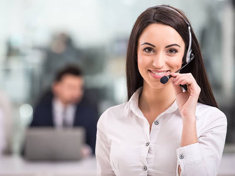 A woman wearing a phone headset in a call center