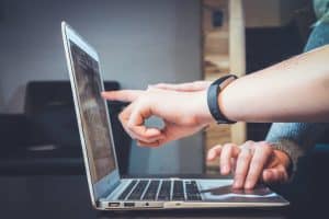 people pointing at a laptop screen