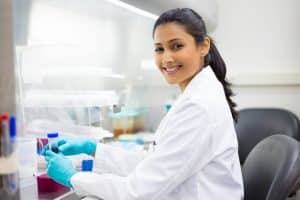 Woman sitting at desk with vial